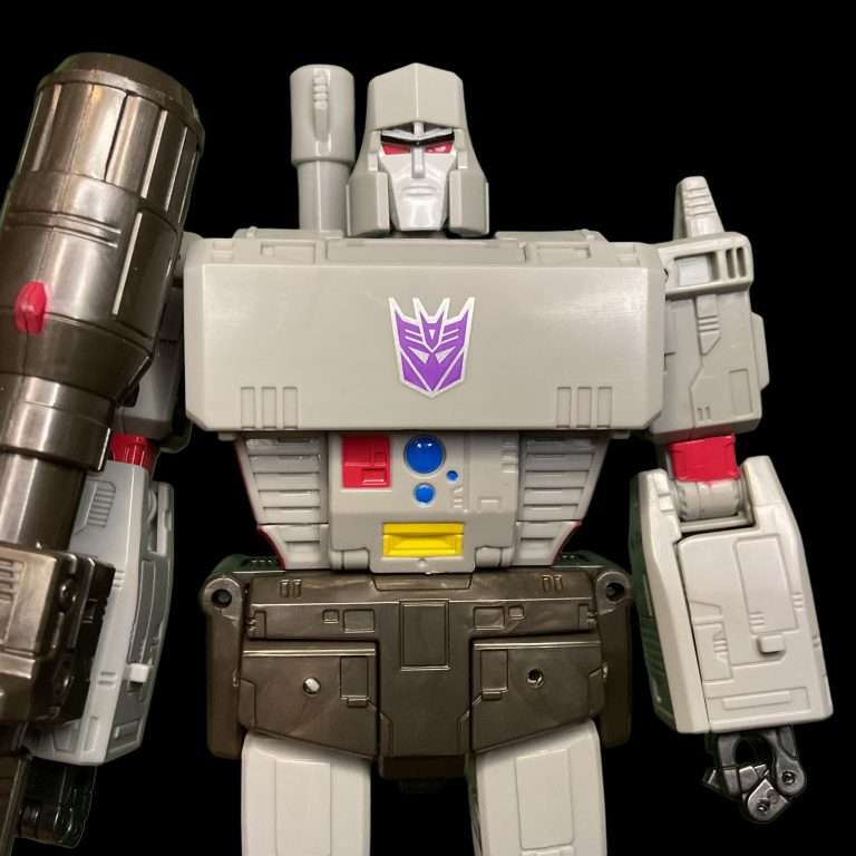 Detailed close-up of Studio Series Megatron's head, showing angular helmet, fierce expression, and precise silver/red deco from 1986 movie design.
