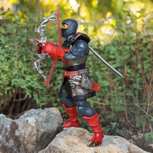 A 7-inch Masterverse New Eternia Ninjor action figure in a dynamic pose, showcasing black armor, red shoulder pauldrons, and a red rope belt against a neutral backdrop.