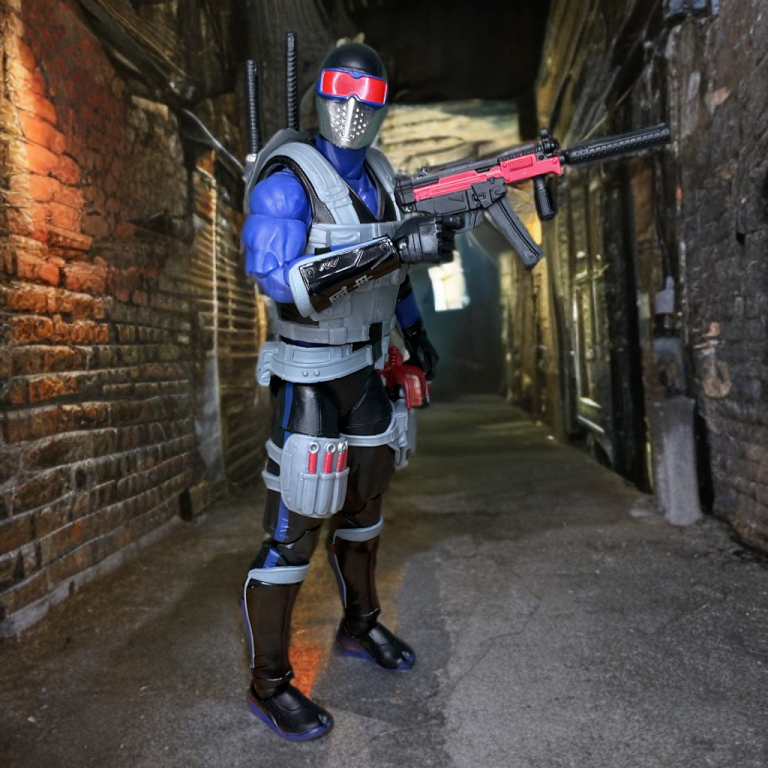 Seitenansicht der G.I. Joe Classified #165 Snake Eyes-Figur, die mit ihrer blauen und grauen Farbgebung im Stil von 1991, der strukturierten Rüstung und der roten Schutzbrille auf einem neutralen Ständer präsentiert wird.