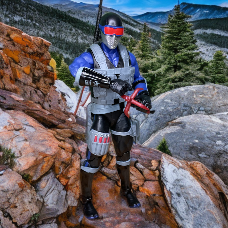 G.I. Joe Classified #165 Snake Eyes-Figur in der geöffneten Verpackung. Sie zeigt die Figur mit Zubehör wie Katanas und einem Enterhaken sowie leuchtenden Karteikartensymbolen.