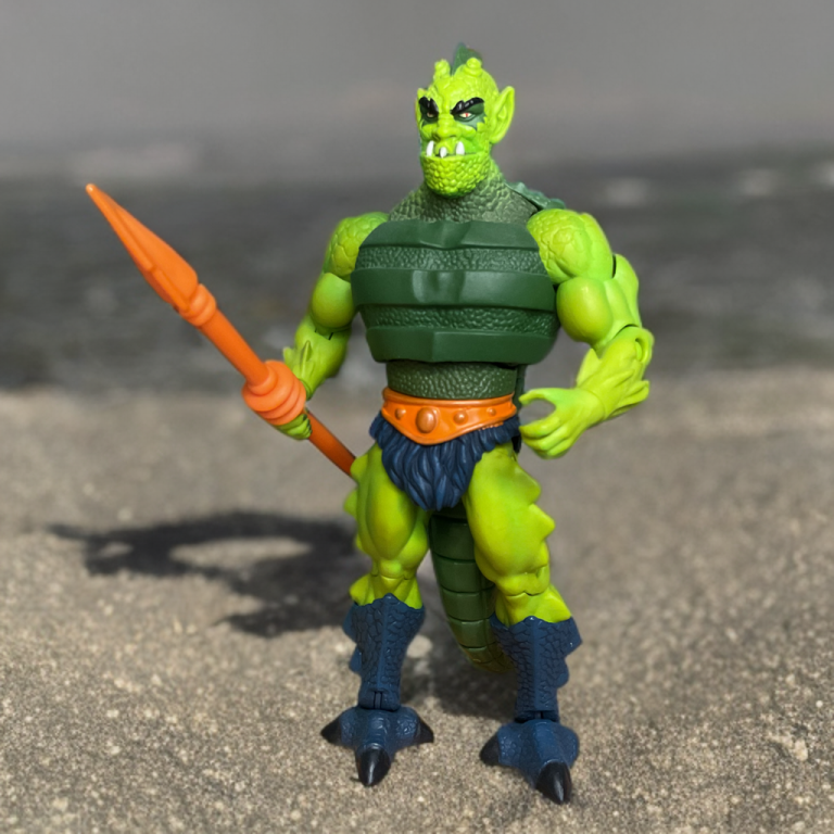 Eine detaillierte MOTU Classics Whiplash-Figur aus dem Jahr 2008 mit aufwändiger Rüstung, einem aufgerollten Schwanz und einem bedrohlichen Gesichtsausdruck, präsentiert auf einem Sammlerständer.