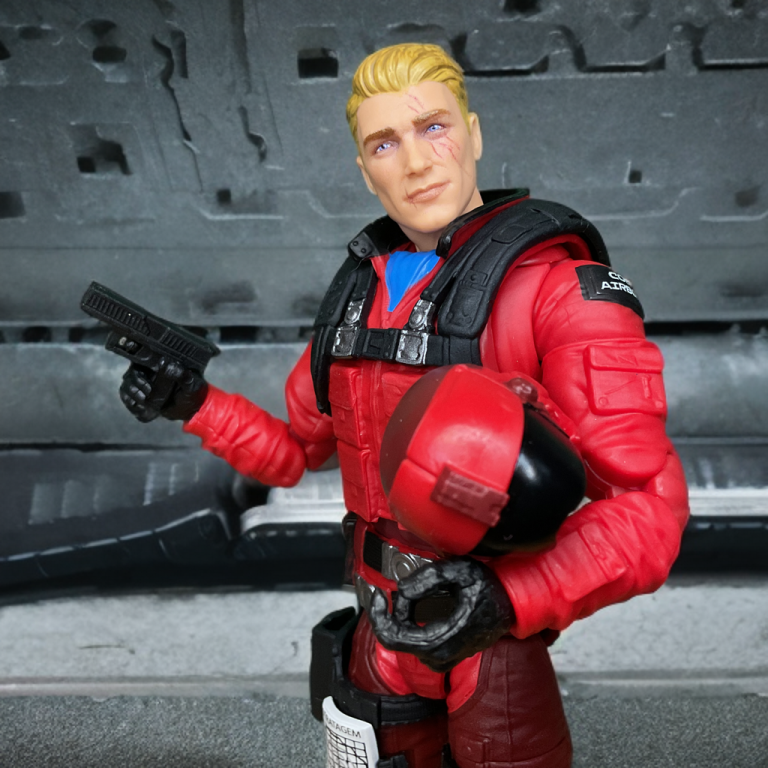 Primer plano de la figura #184 Comadreja Salvaje de la Serie Clasificada de G.I. Joe de 15 cm, mostrando su traje de vuelo rojo y azul, la cabeza rubia sin máscara con cicatrices y el detallado arnés con hebillas plateadas.