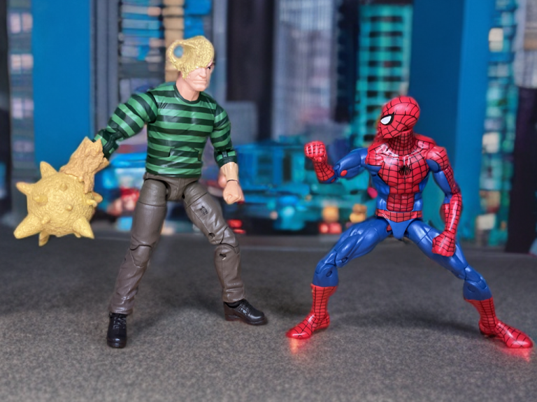 La figurine Marvel Legends Sandman Retro 2025 se tient dans une pose d'action avec un poing de sable en forme de marteau, prêt à combattre Spider-Man dans une scène de style bande dessinée.