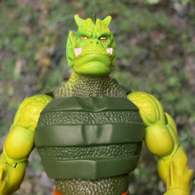 Eine Nahaufnahme von MOTU Classics Whiplash mit einem 200-fach vergrößerten Kopf, der seine scharfen Zähne und roten Augen hervorhebt.