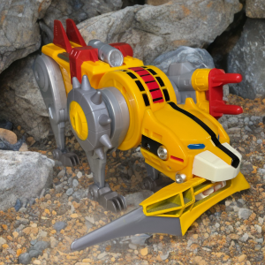 The Yellow Lion stands on a sandy desert dune, its sturdy build and articulated tail highlighted in Playmates’ Voltron collection.