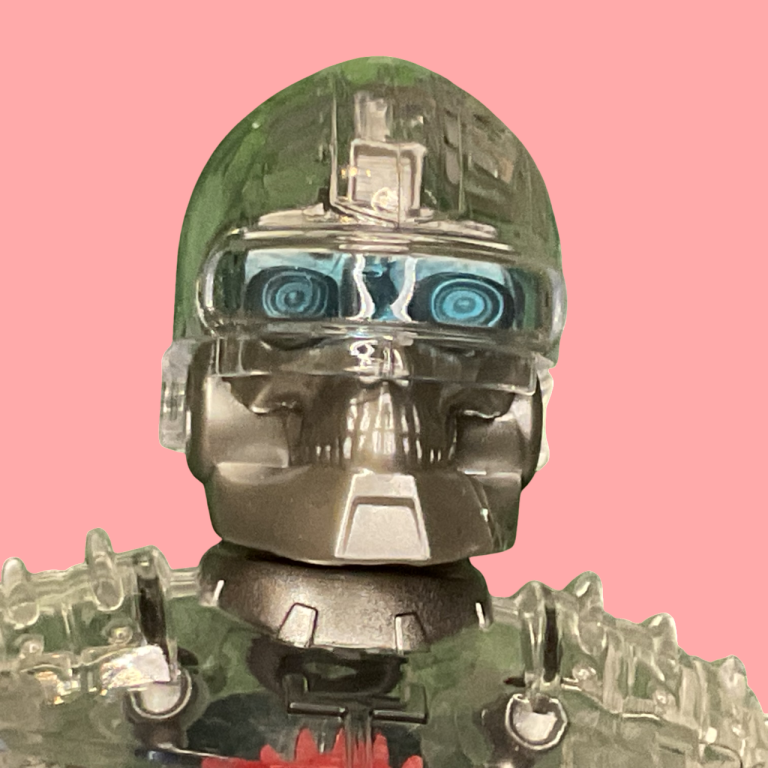 A figura do Robô do Masterverse, em close-up em um fundo neutro.