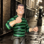 Die Sandman-Figur 2025 in ihrer Retro-Verpackung mit sandfarbener Skulptur und grün-schwarzen Streifen steht in einem Regal mit anderen Marvel Legends-Figuren.