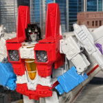 Starscream, the ambitious Decepticon second-in-command, in his classic Generation 1 robot mode with signature red, white, and blue color scheme and wing structures.