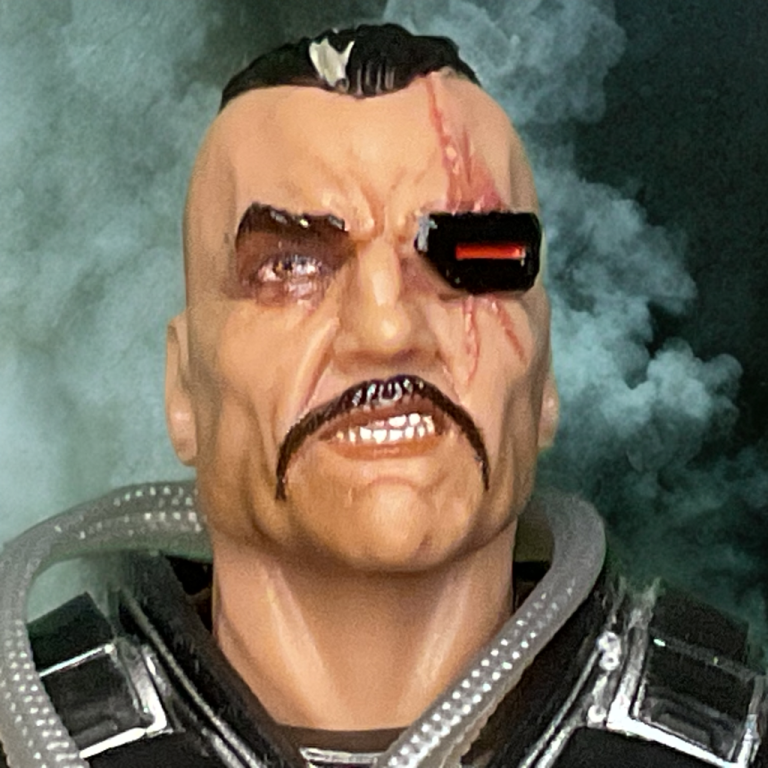 Primer plano de la figura del Mayor Bludd #166, con la cara llena de cicatrices y un parche en el ojo, chaleco táctico marrón y un collar de placas de identificación.