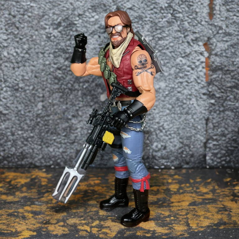 Detailed sculpt of Monkeywrench’s tattooed arms and grenade bandolier, highlighting ripped jeans and chrome belt chains on the 6-inch figure.