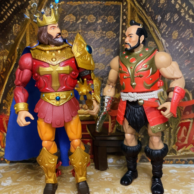 König Randor und Jitsu Actionfiguren stehen in einem Raum mit einem goldenen Wandteppich hinter ihnen.