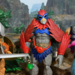 He-Man, Stratos, and Fisto confront Faker with a mountainous background.