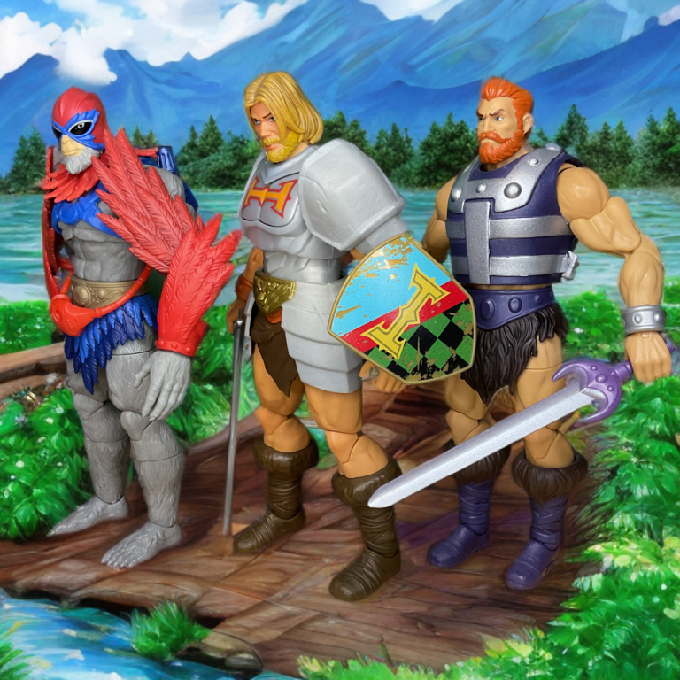 Die Actionfiguren Stratos, He-Man und Fisto stehen auf einer Holzbrücke über einem Bach mit einem Wald im Hintergrund.