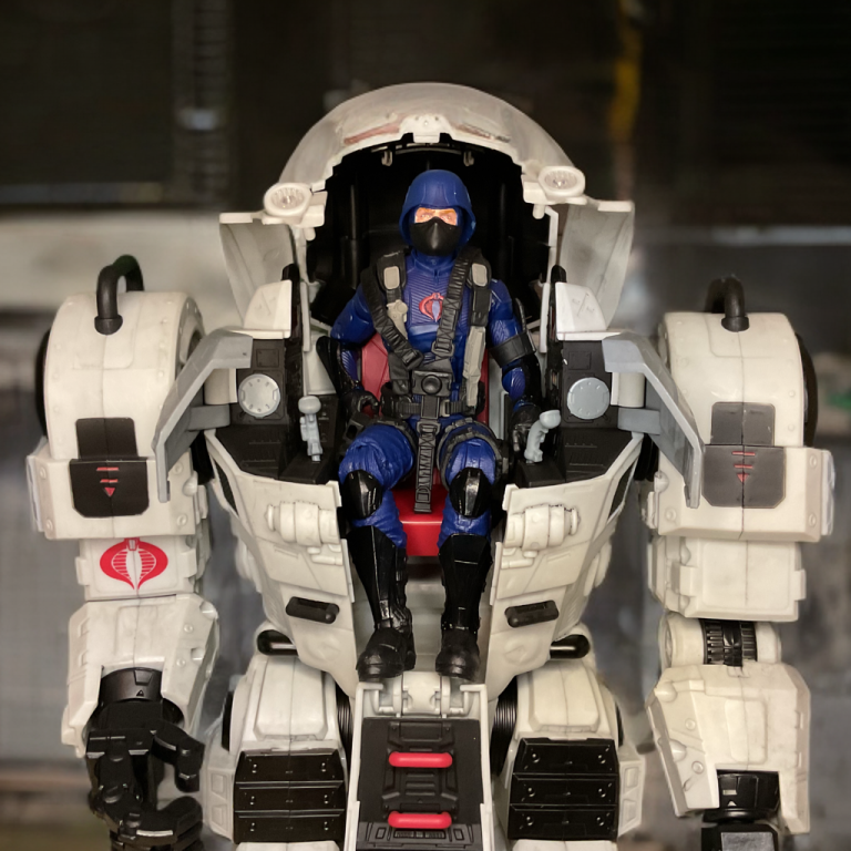 Uma figura do traje G.I. Joe Classified Cobra S.N.A.K.E. com o soldado Cobra sentado nos controles.