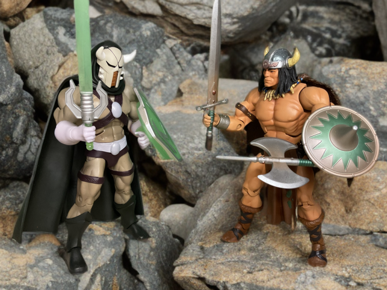 Lord Masque dueling Vikor with swords clashing on uneven rocks, cloaks and armor in motion amid a barren landscape.