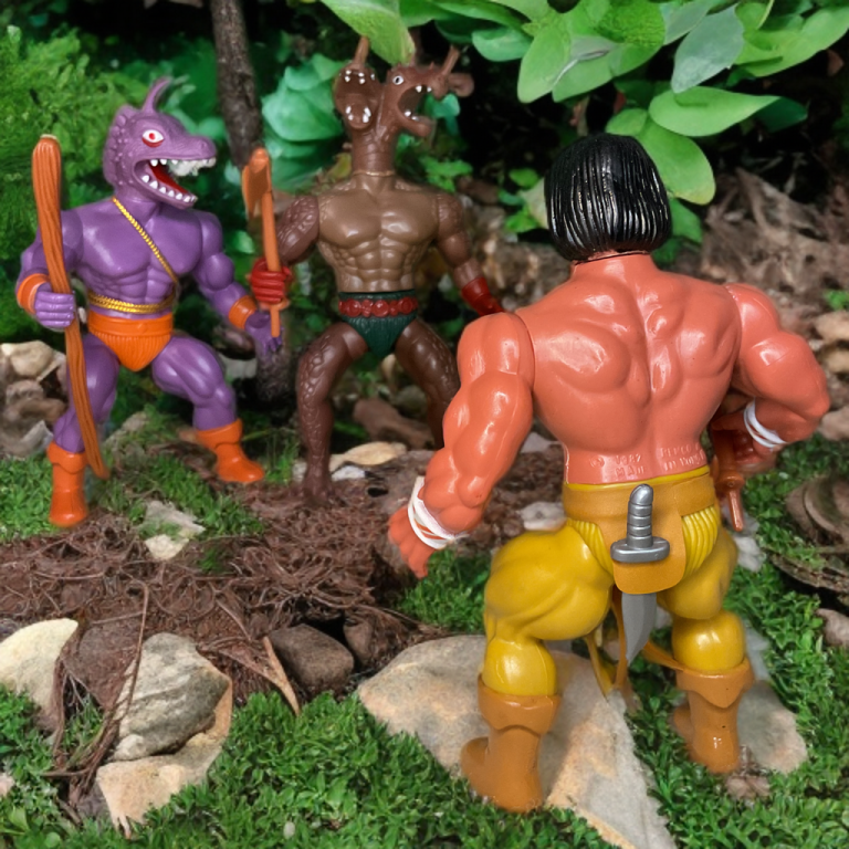 Una figura retro de Arak permanece alerta en una jungla, divisando a Gecko e Hydraz en la distancia, sus monstruosas formas resaltadas en una sesión fotográfica con elementos naturales como helechos y rocas.