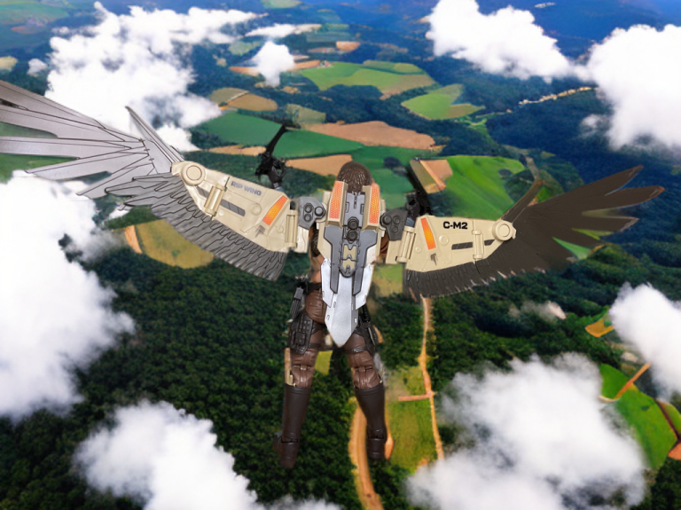 The G.I. Joe Classified Series #139 Chip "Raptor" Talon figure, with a sleek vest and feather-accented gloves, posed with the C-M2 Daedalus Jet Wing Pack flying over the green countryside.