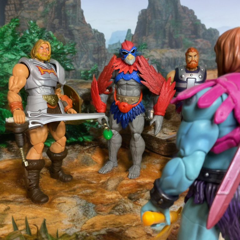 Aktionsfiguren von He-Man, Stratos und Fisto stehen Faker am Eingang einer Steinhöhle gegenüber.
