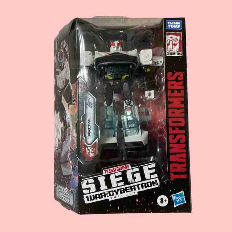 Description of Prowl's standard Siege packaging with windowed robot view, back panel showing 14-step transformation and Battle Master compatibility. Accessories include a white blaster, clear light bar with red/black details, and 5mm ports for modular weapons, evoking G1 acid pellet gun.
