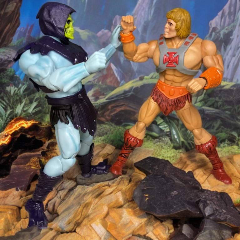 He-Man und Skeletor schauen sich in einer Schlucht vor einer Kulisse aus zerklüfteten Felsen und feurigem Licht in die Augen.