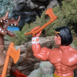 Arak, a 1982 Remco figure, stands triumphantly on a mountain peak with axe raised against the fearsome Warrior Beasts Hydraz.