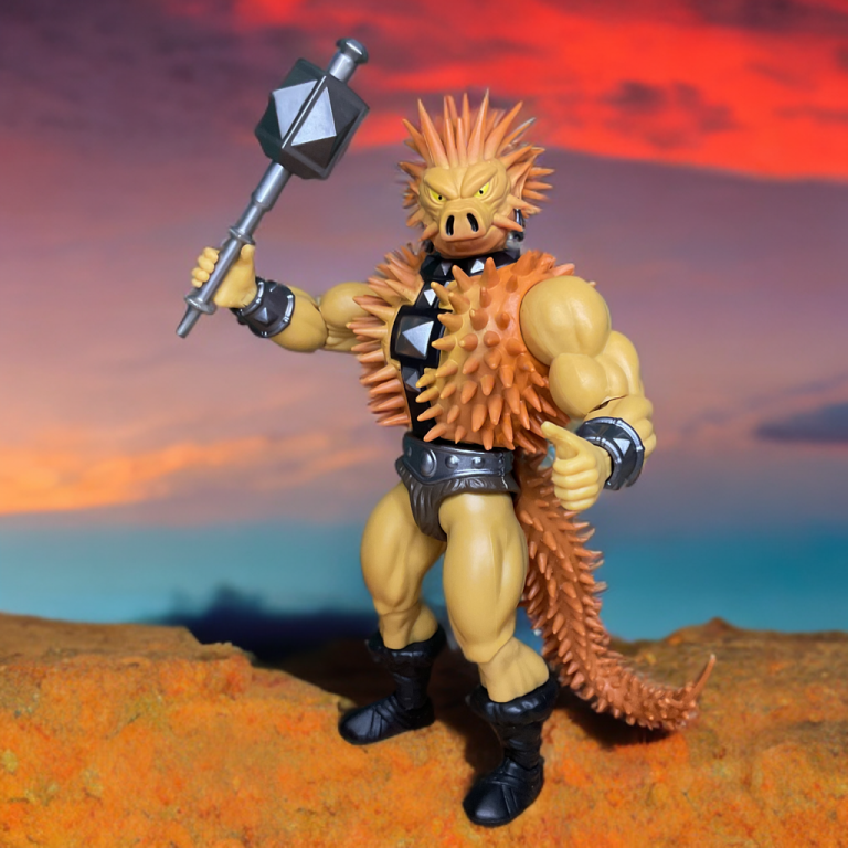 Spikor, a spiky brown action figure, poses with a raised mace and trident hand. The box showcases a detailed ink sketch of Spikor, with orange accents and concept art details.