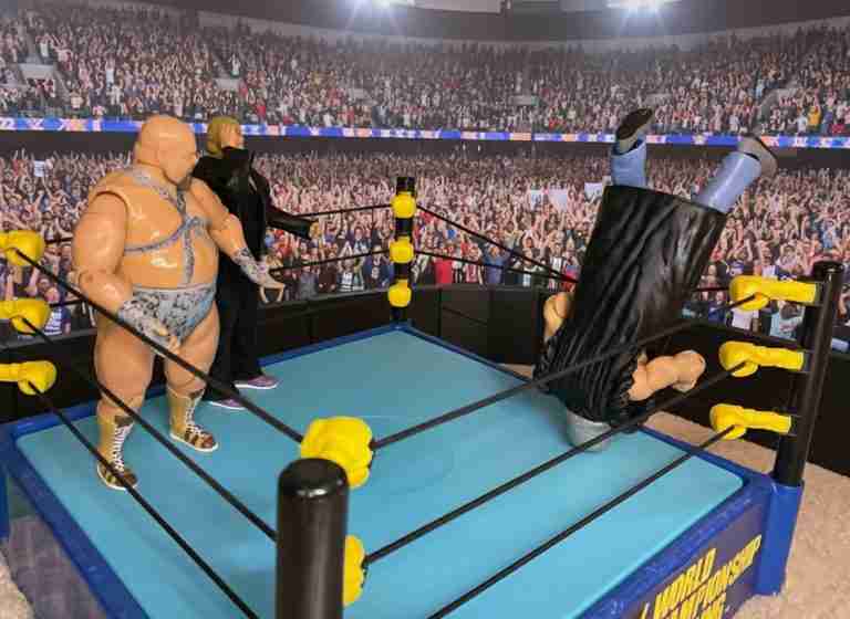 Die Shockmaster-Actionfigur betritt dramatisch den Ring über das oberste Seil, während Booger und Race aus der Ecke zusehen.