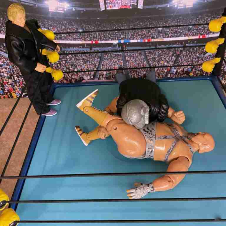 Die Shockmaster-Actionfigur führt einen Big Splash auf Bastion Booger aus und hakt das Bein für einen Pinfall ein.