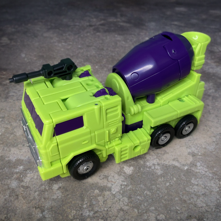 Mixmaster’s spinning cement mixer drum in action, yellow-green deco popping against a workshop table in this Studio Series combiner preview.