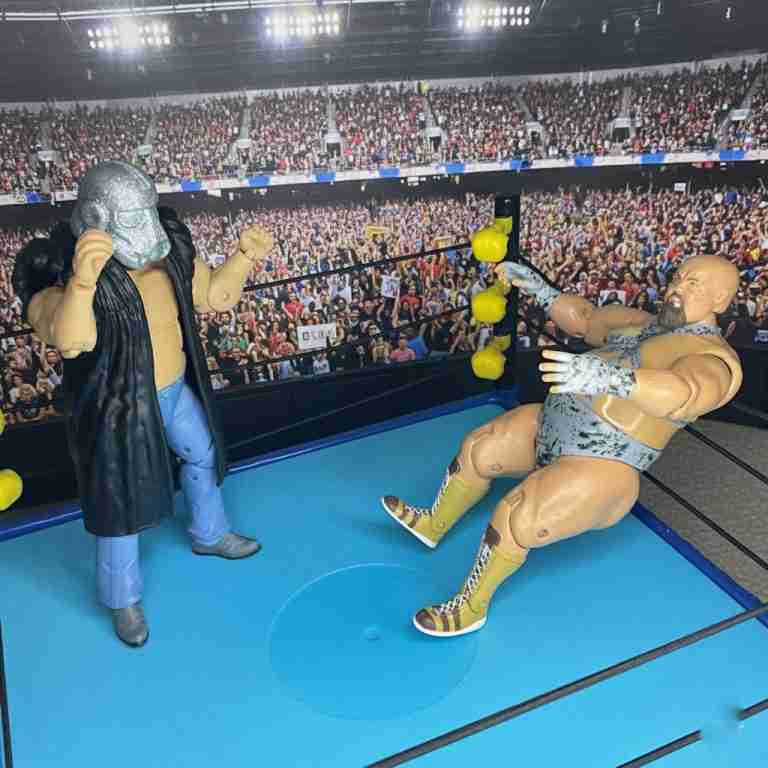 Die Shockmaster-Actionfigur wirft Bastion Booger für einen Irish Whip in die Seile, während Race sich draußen erholt.