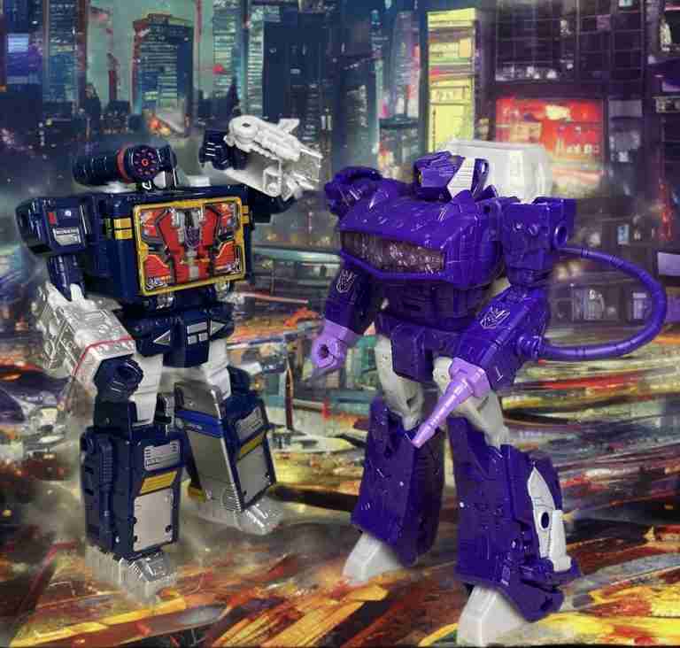 Blue Soundwave toy on left with blaster, purple Shockwave on right with cannon, posed confrontationally in a vibrant, colorful urban night scene.