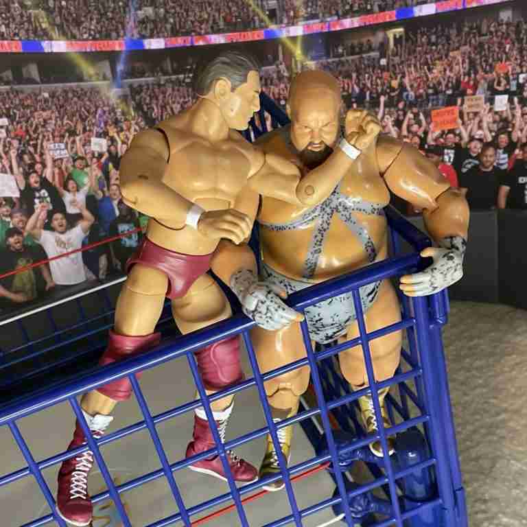 Regal verpasst Bastion Booger oben am Stahlkäfig einen harten Uppercut-Unterarm.