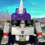 Megatron seated on purple throne with spike, holding cannon, set against a colorful desert landscape with mountains and distant blasts.