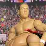 Lord Steven Regal zeigt einen Front-Face-Lock in einer vollen Arena mit Fans.