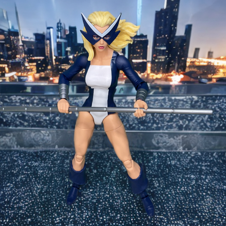 Mockingbird poses before a cityscape skyline.